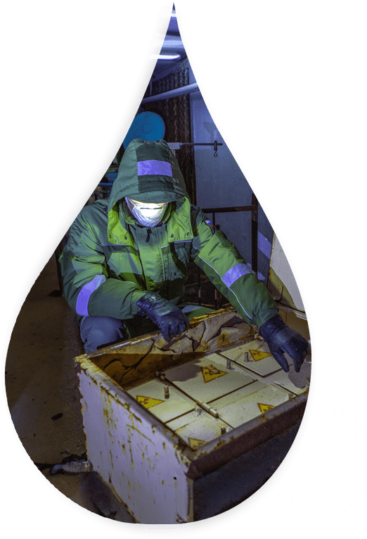 A person in green jacket and gloves putting food into crate.